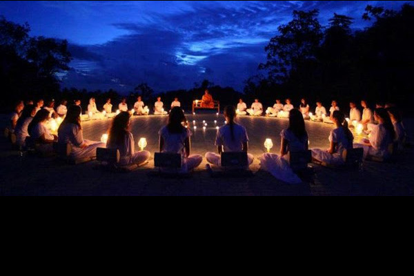 group sitting outside in candle light